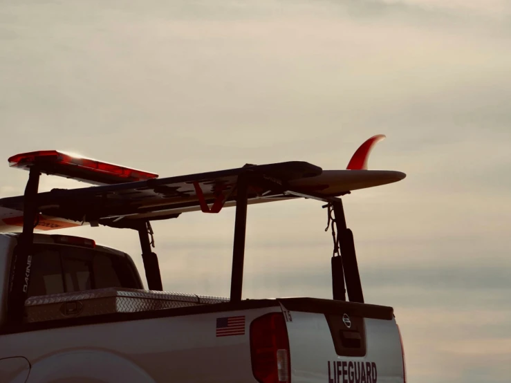 the back of a truck with surf boards on its rack