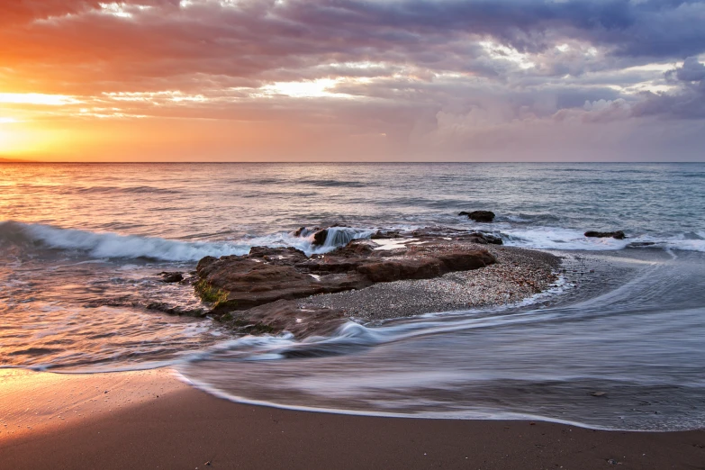 a wave hitting on top of a rock