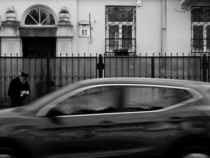 a person walking by a building with a gate