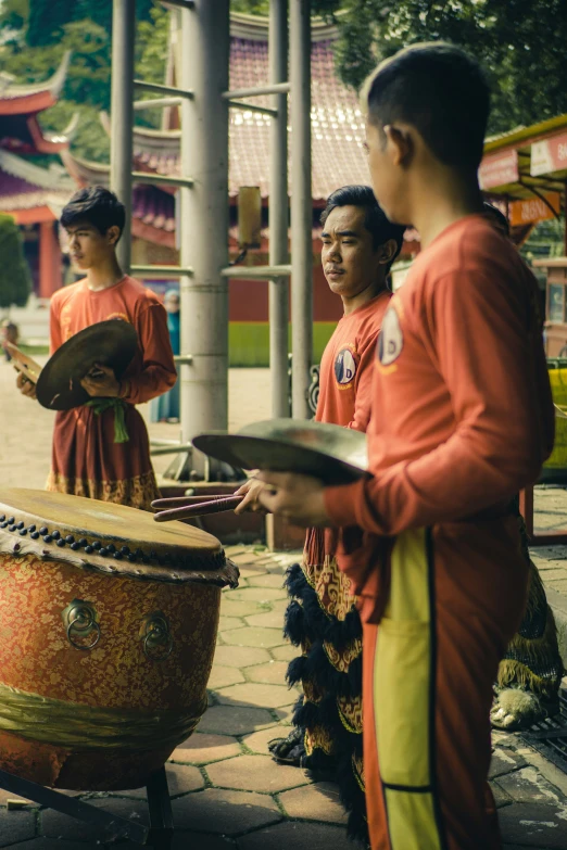 a group of people standing near a drum