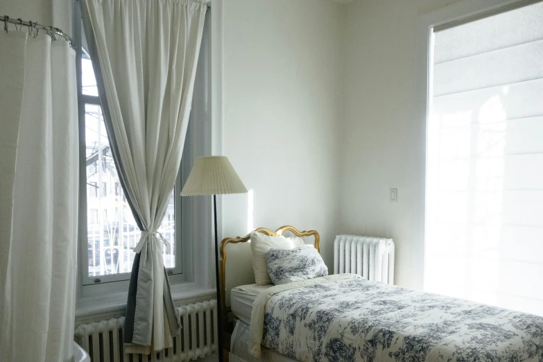 a bedroom with curtains, bed and window