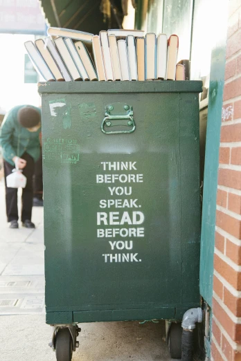 some books are stacked on top of a green cart