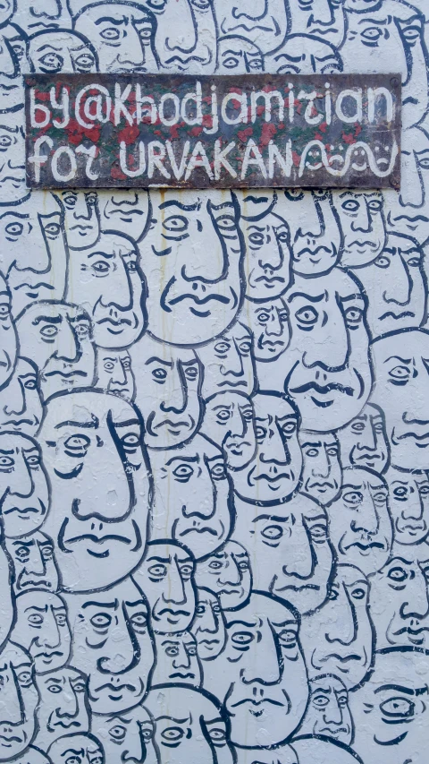 graffiti on the side of a wall that has a group of people drawn over with words and faces