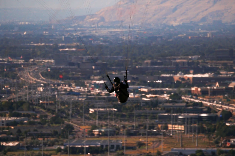 a parachute parachutist is taking flight over the city