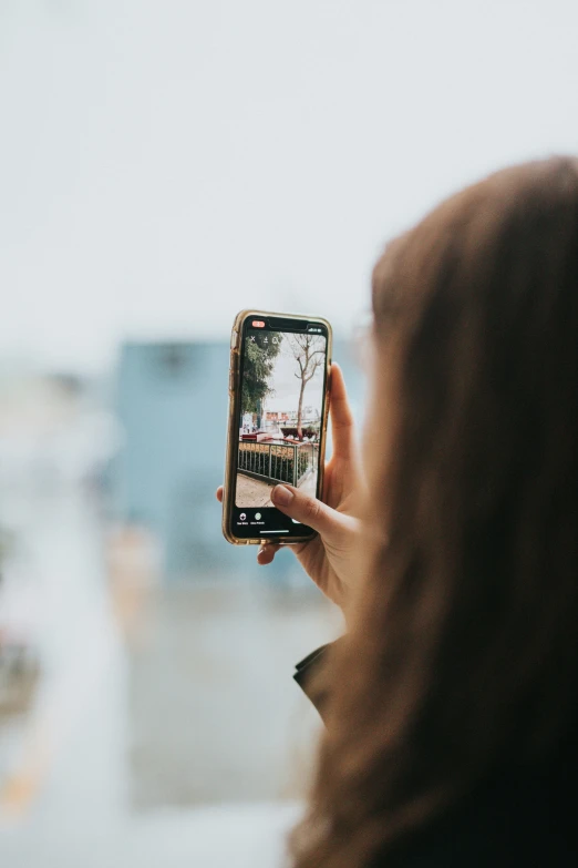 the woman is taking a picture with her cellphone