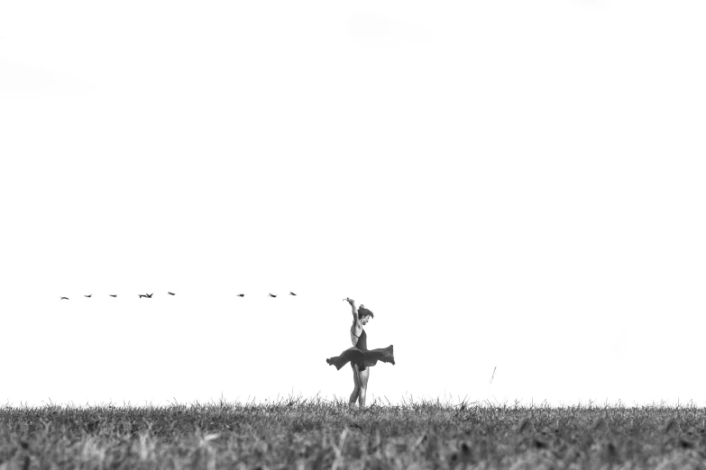 a person holding an object in the air on a grass field