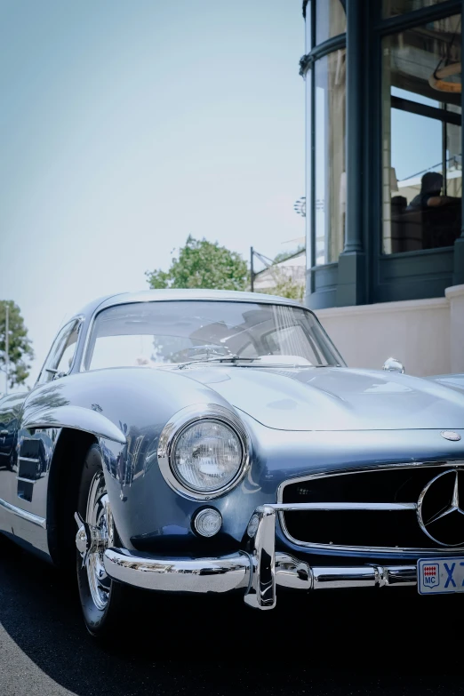 a silver classic car is sitting parked near some buildings