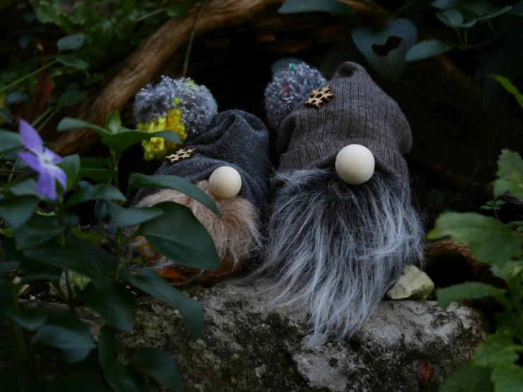 two toys laying on a large rock outside