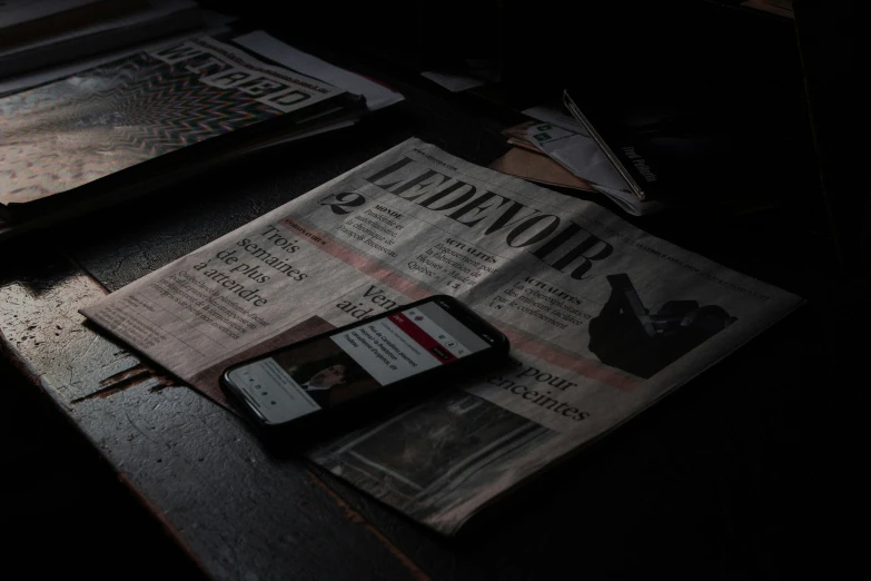 a cellphone and newspaper on a table