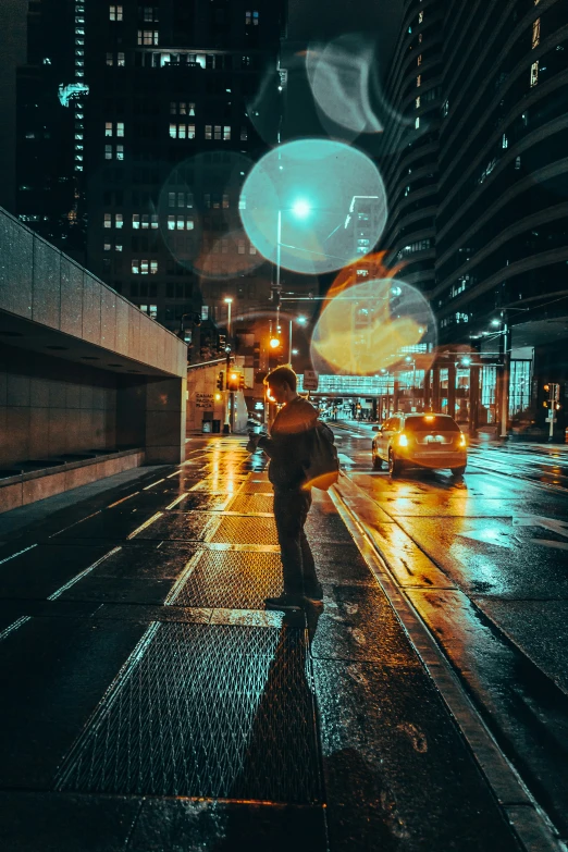 a man is walking on a sidewalk at night with a yellow umbrella