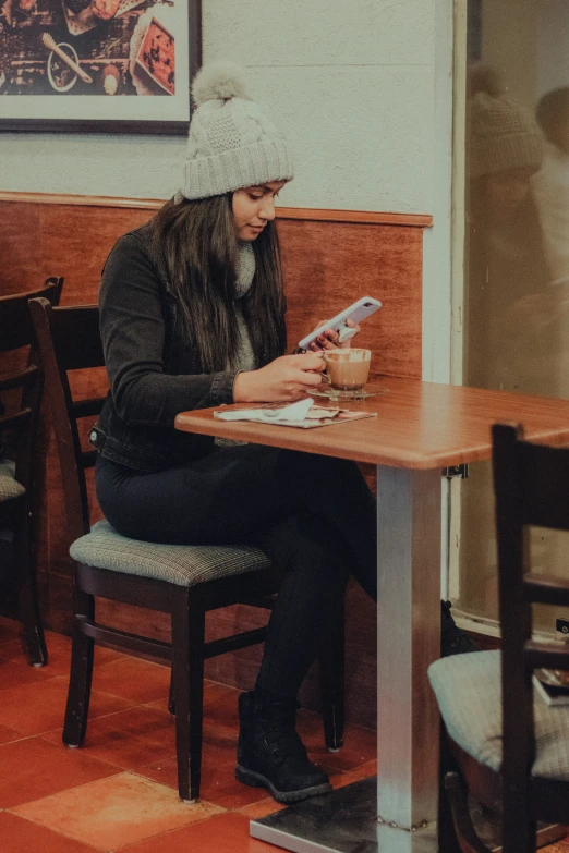 a man sitting at a table looking at his cell phone