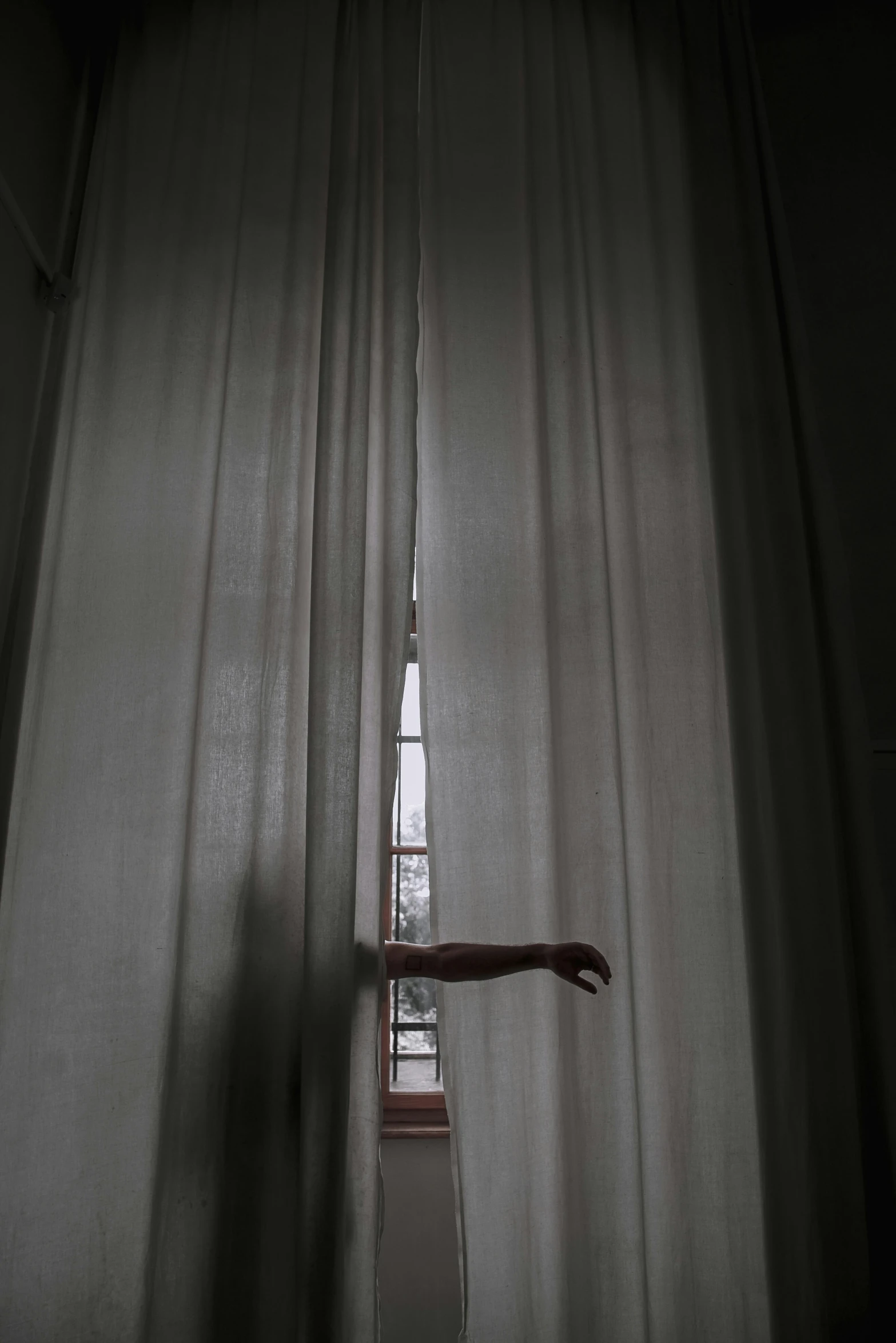 the curtain is partially open with a light on