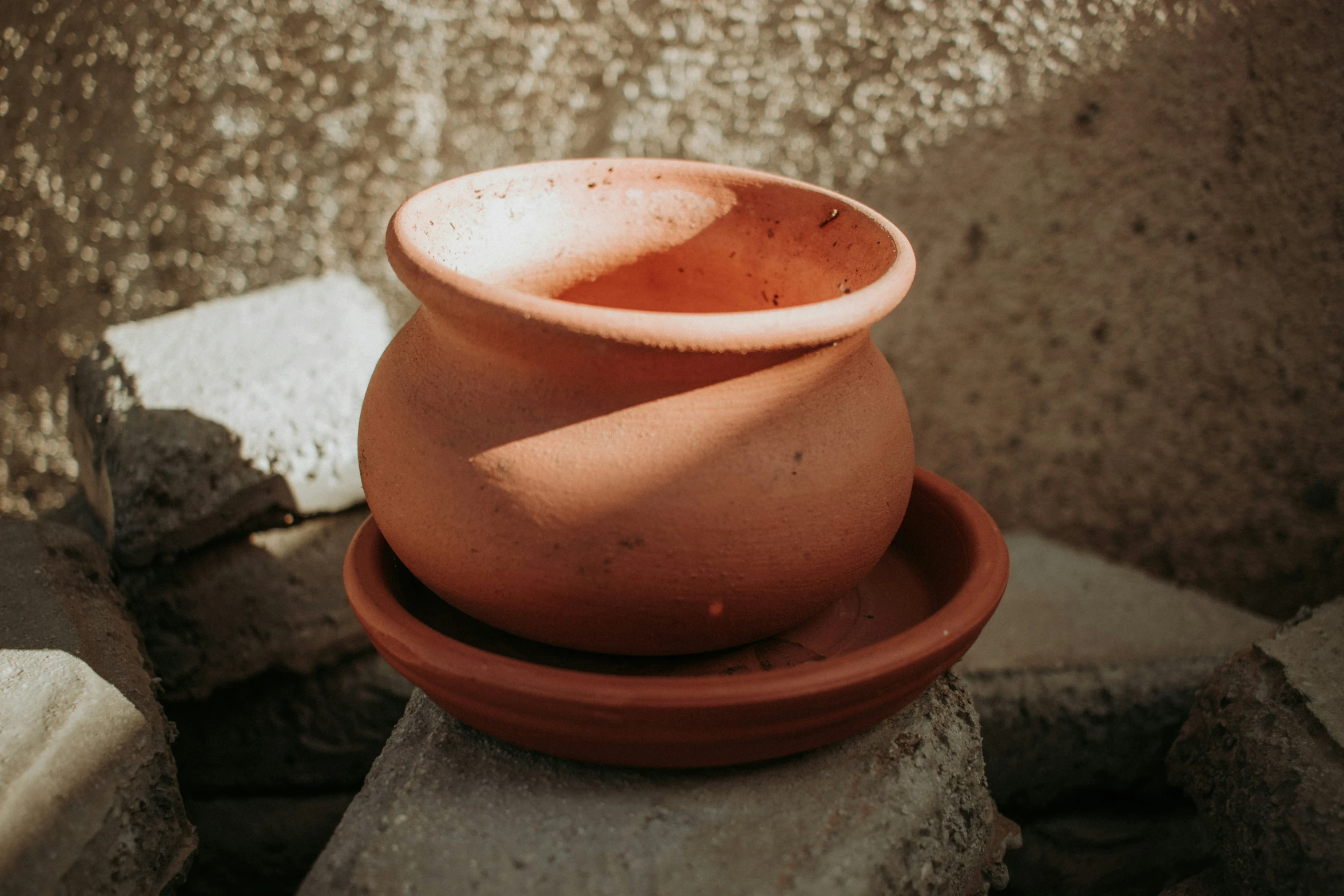 a large bowl and saucer are sitting on rocks