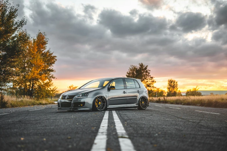 a car sits on the side of the road during the sunset