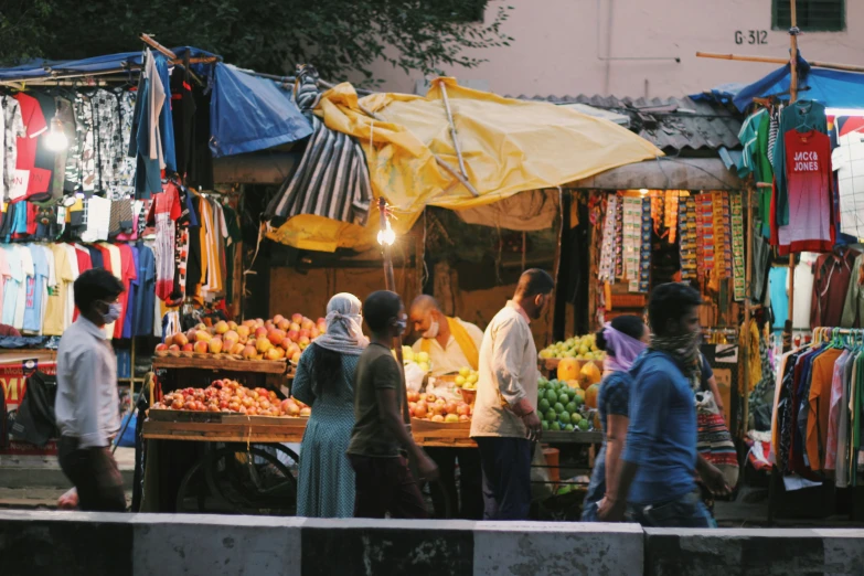 a man sells fruit on the sidewalk at an outdoor market