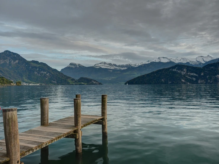 a pier in the water with mountains in the distance