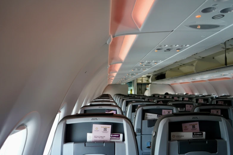 an airplane aisle with empty seats, labels on them