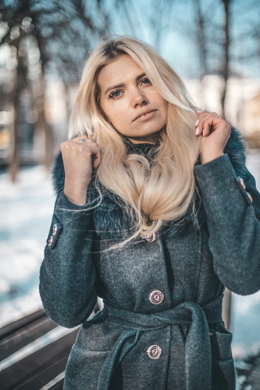 an attractive young woman standing on top of a bench