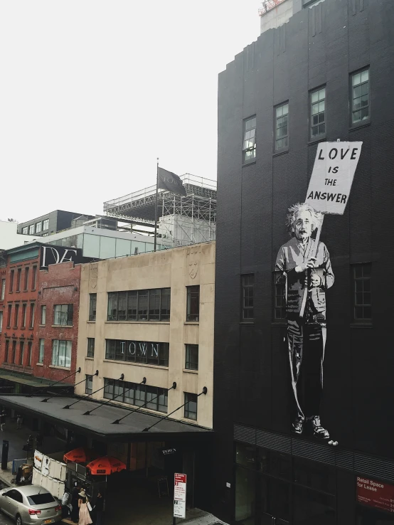 the large mural depicts a man with a sign saying love