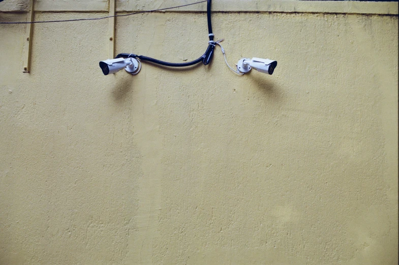 two cameras mounted on the side of a building