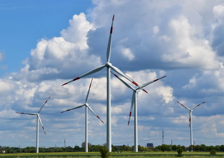 the wind turbines are standing tall in the field