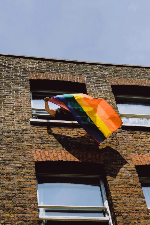 a rainbow colored kite is in the window