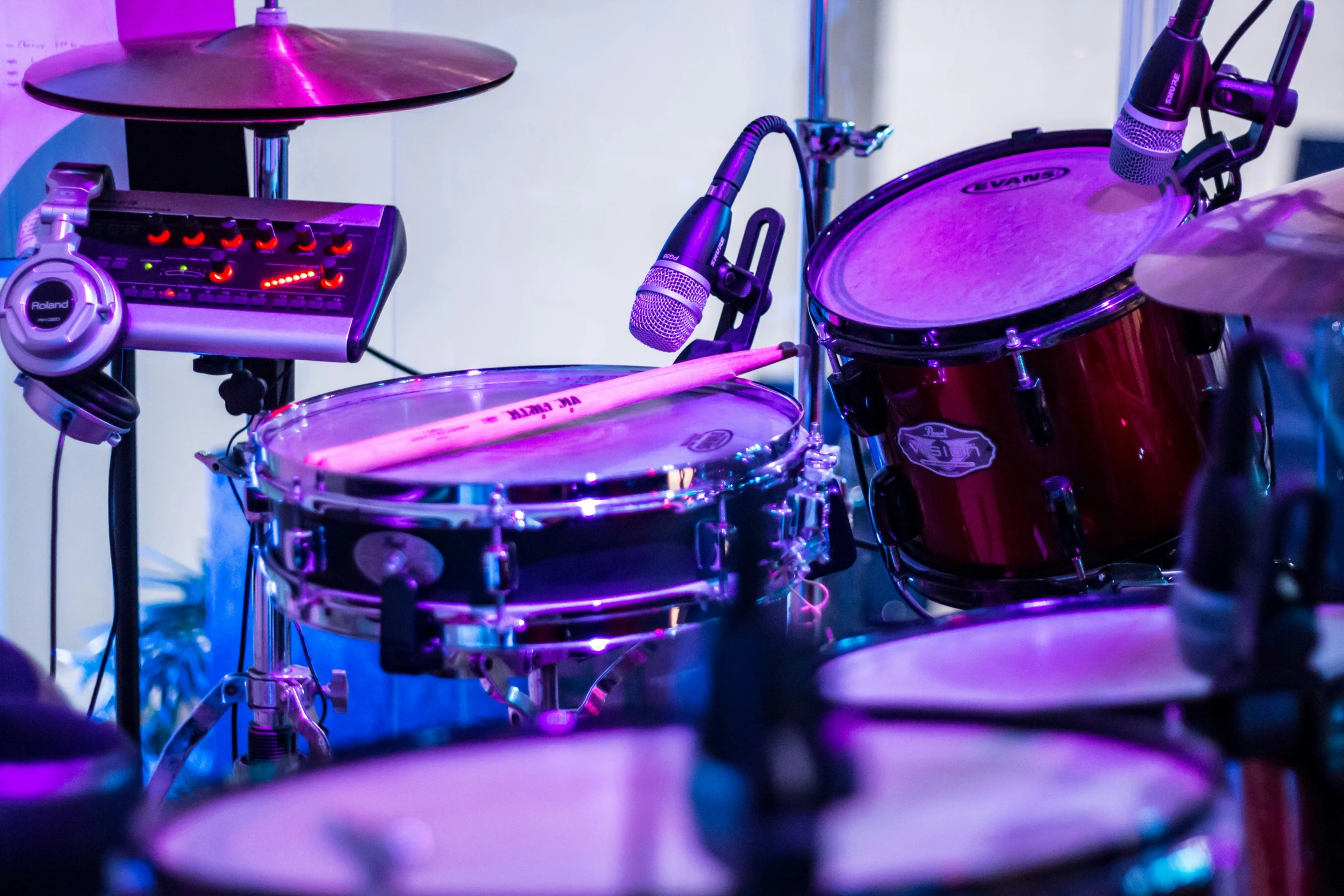 a drum set is lit with the color of purple