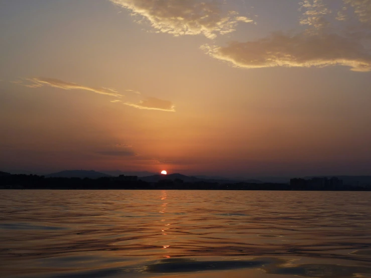 a sun setting over some water and clouds