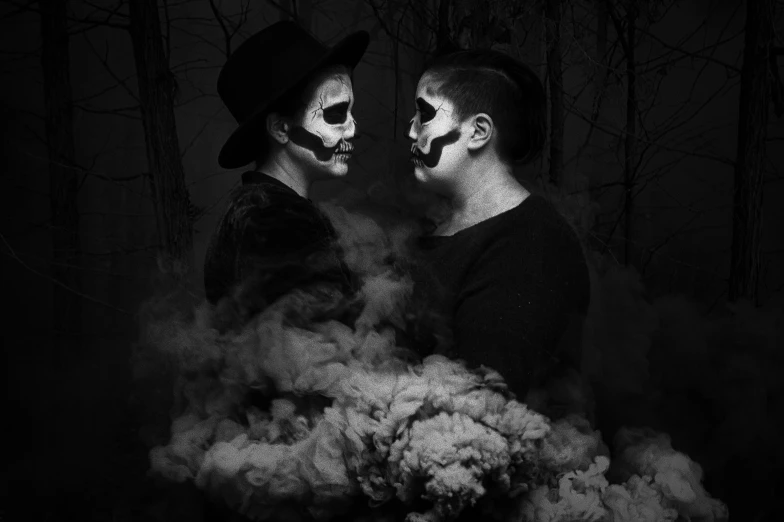 two men dressed as skeleton faces in a creepy black and white po