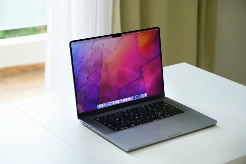 a laptop computer with an open screen sitting on a white desk