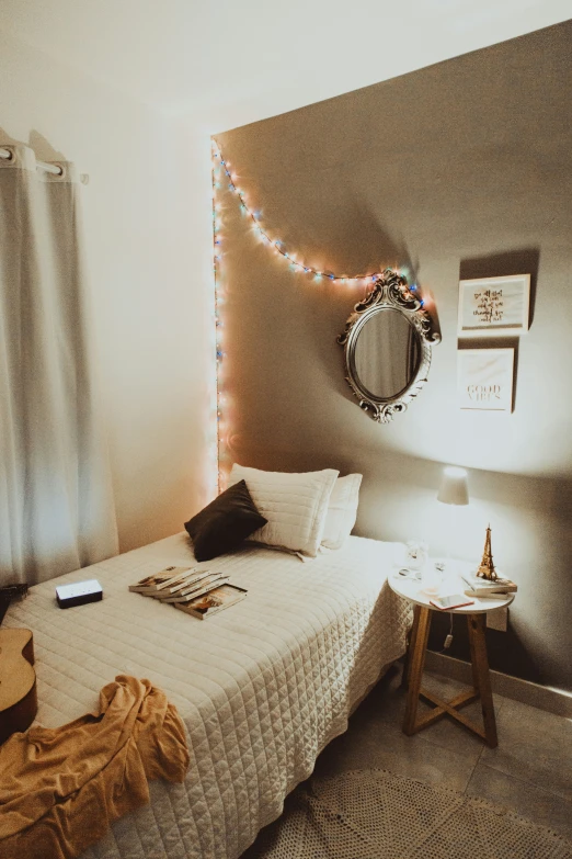 this is a bed with white sheets and string lights
