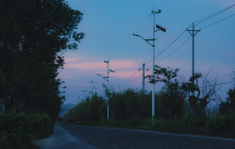 the night sky and light poles near a road