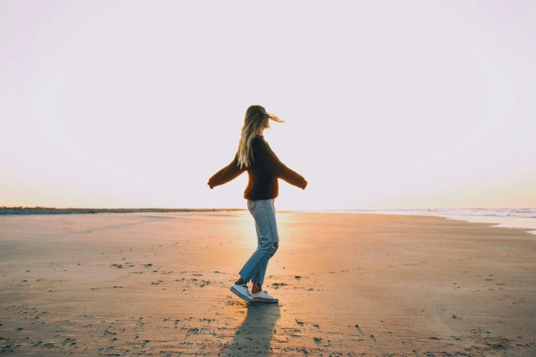 a woman on the beach in front of the ocean