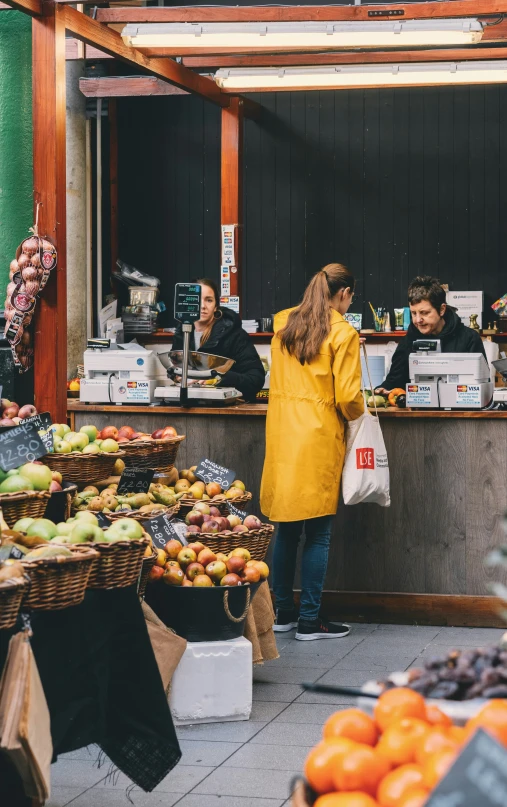 people are purchasing fruits at an outdoor market