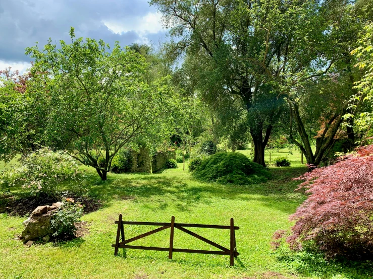 an open grassy field with a wooden gate and a few rocks