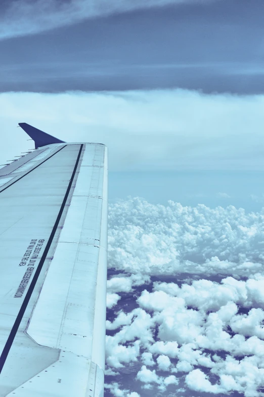 a jet plane wing with the wing extended in a blue sky