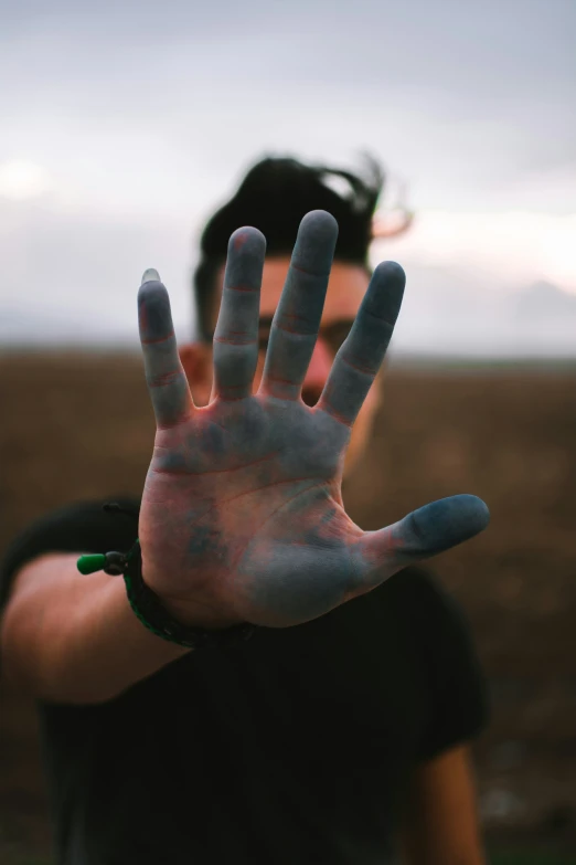 a man's hand with paint and black sleeves