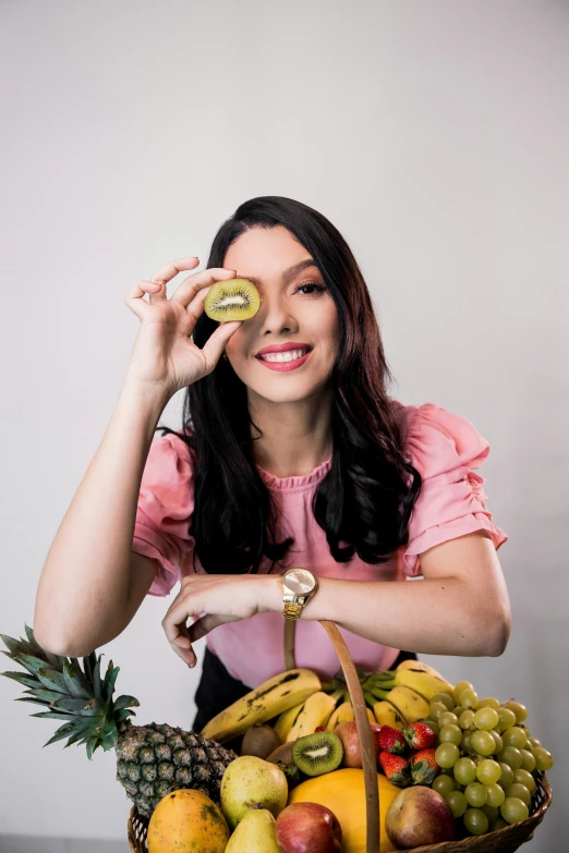 a person holds a snack in their hand and a basket of fruit