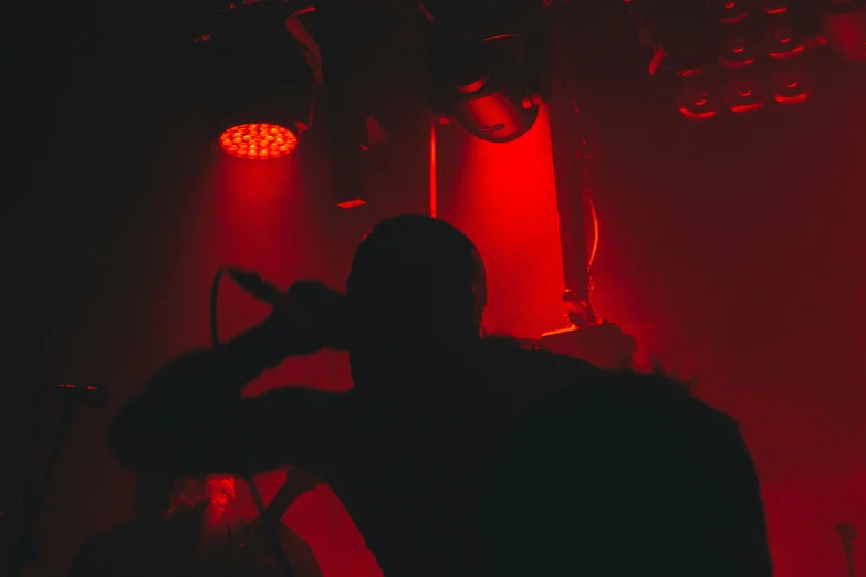 a man on stage looking at a bright light