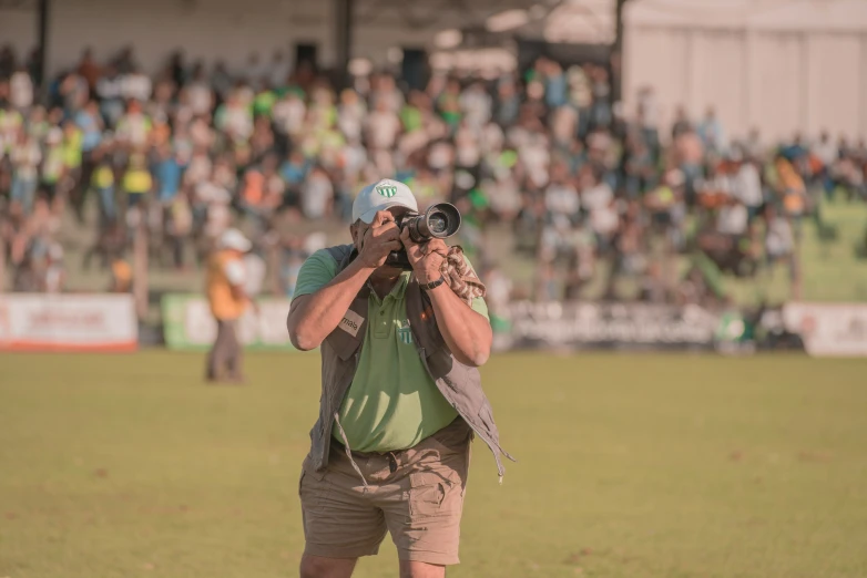 a pographer on the field taking pictures of a crowd