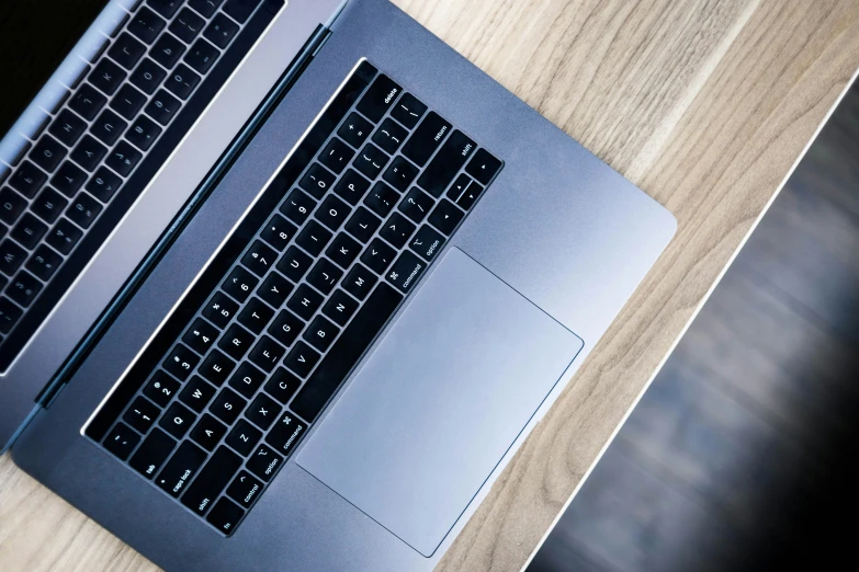 a close up of two laptops on a wooden table