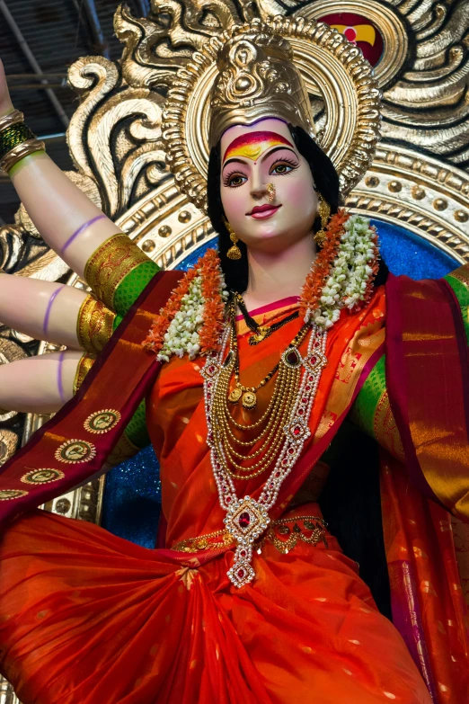 a statue of a female dancer with gold jewelry on her shoulders