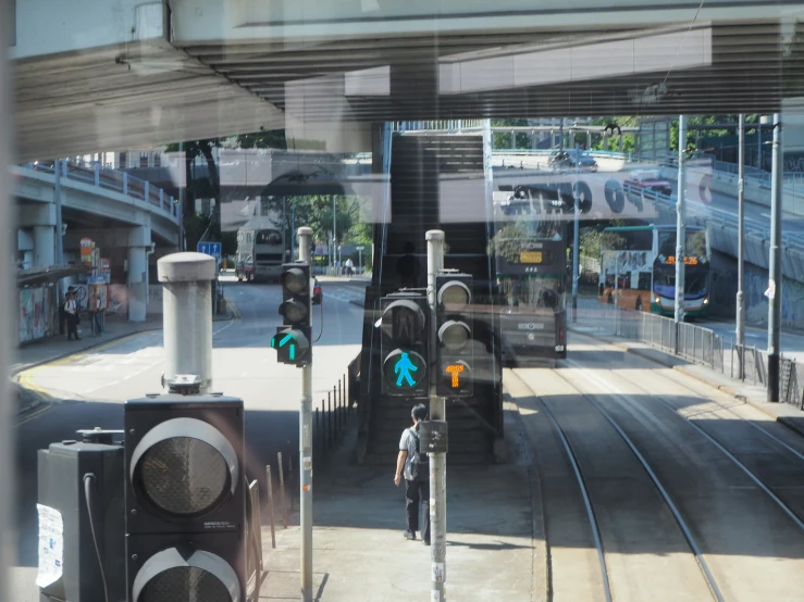 a window with view of a street, traffic lights and train tracks