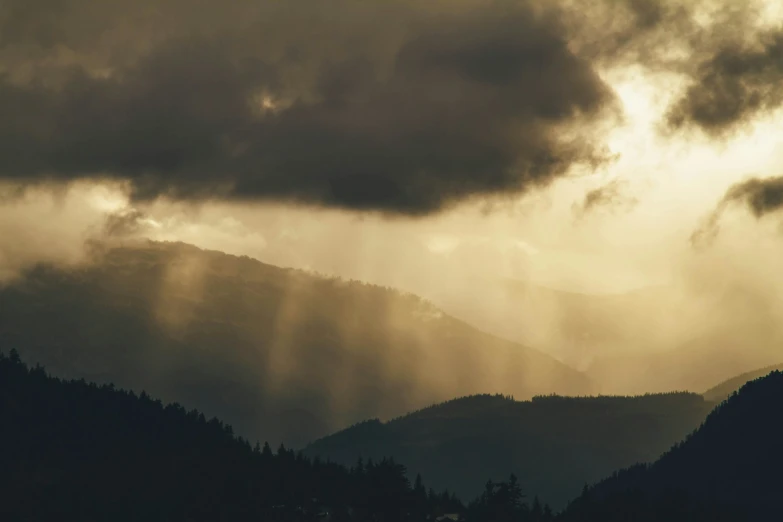 a couple of large mountains are under some clouds