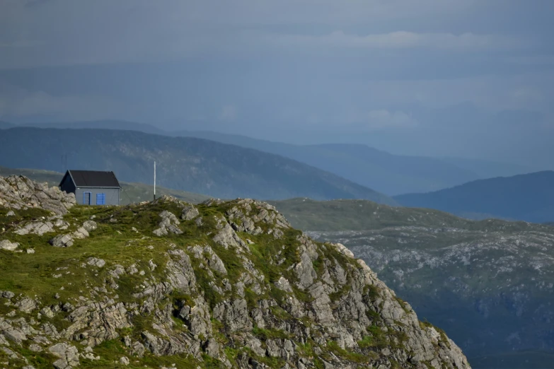 a small house perched on top of a rocky mountain