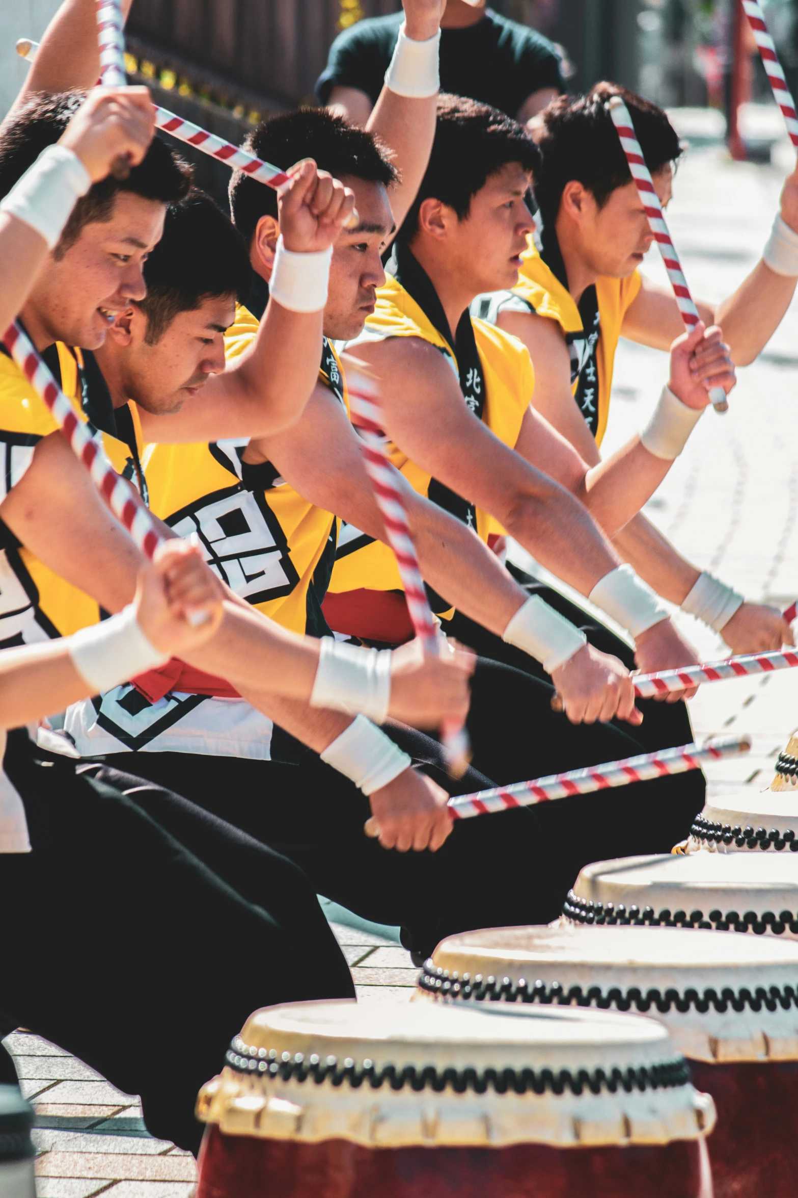 a group of young men sitting around wooden drum