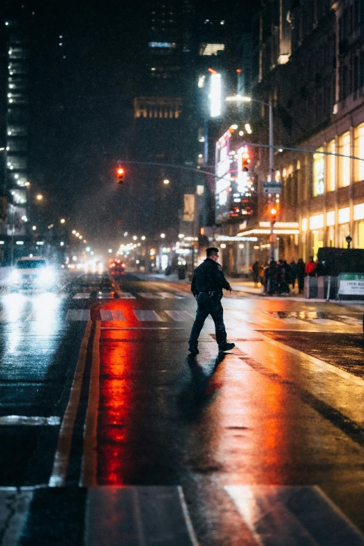 people are walking on the sidewalk in the rain