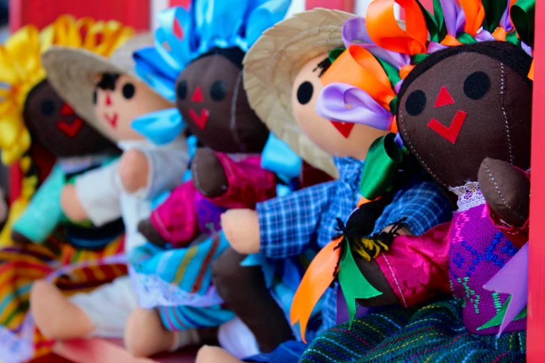 many stuffed toy dolls dressed up and in colorful outfits