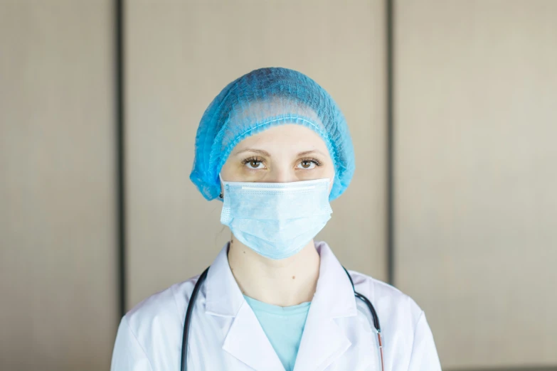 a woman in scrubs and a surgical mask on