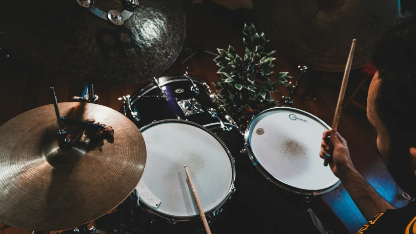 a drummer is holding a drumstick in front of two sets of drums